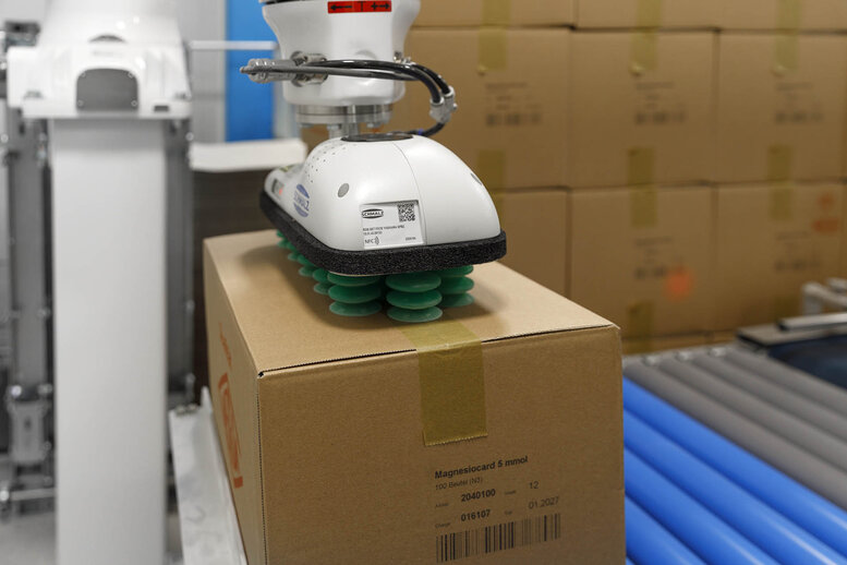 Cobot palettiert in der Pharma Industrie